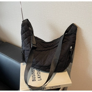 Detailed side view of black quilted nylon moon bag featuring reinforced stitching and zippers