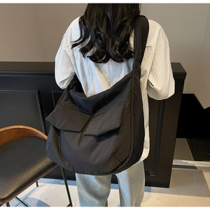 Detailed back view of a black large-capacity crossbody bag with dual front flap pockets