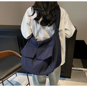 Detail of navy blue large capacity canvas messenger bag with dual front flap pockets
