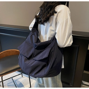 Detail showing high-capacity navy tote bag with dual front flap pockets and wide strap