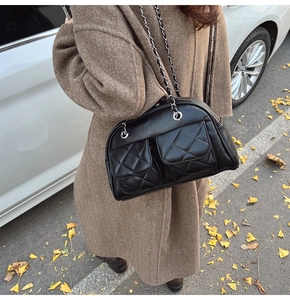 Detailed view of a vintage black quilted leather bag with silver chain straps in autumn setting
