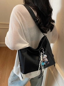 Minimalist black faux leather underarm bucket bag with bear charm and COCO 72 embossing