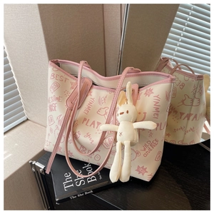 Detail of large tote bag with pink graffiti prints and a cute rabbit plush charm