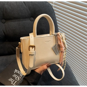 Detail of a beige PU leather mini box bag featuring decorative tennis racket charms