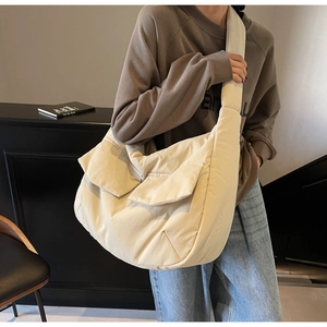 Detail of off-white oversized tote bag with two front flap pockets and wide shoulder strap