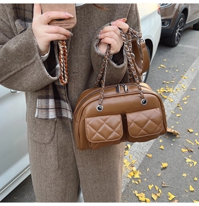 Detail of caramel crossbody bag featuring double quilted pockets and silver chain strap