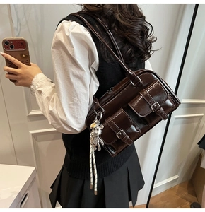 Detail view of dark brown vintage underarm bag with double front flap pockets and silver buckles