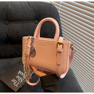 Detail of pink PU leather mini handbag with round handle and tennis racket charm