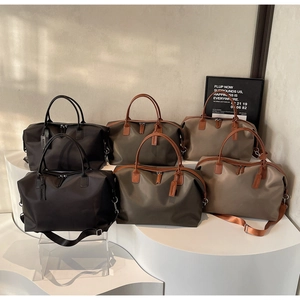 Three nylon travel tote bags in black, green and khaki displayed on white pedestals