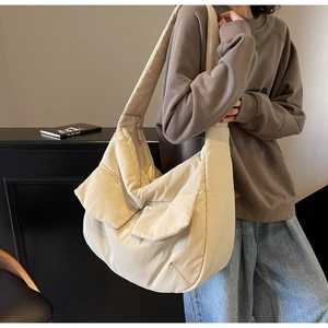 Detail of beige large capacity tote bag with front flap pockets and wide shoulder strap