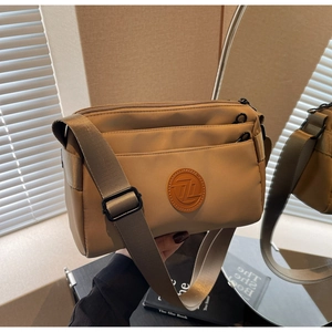 Détail du sac bandoulière kaki en nylon avec plusieurs compartiments zippés et bandoulière