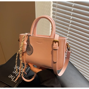 Detail of pink small tote bag with silver mesh racket charm and woven knot decor