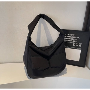 Minimalist black quilted puffer tote bag with large double front pockets and wide strap
