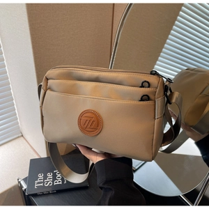 Détail du sac bandoulière en nylon kaki avec trois compartiments zippés et sangle