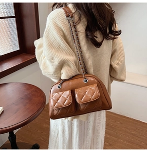 Brown quilted pillow bag with silver chain strap shown in a real-life fashion setting