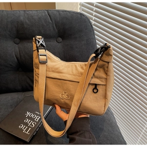 Dettaglio della borsa a mezzaluna in nylon kaki con tasca a zip e logo dorato