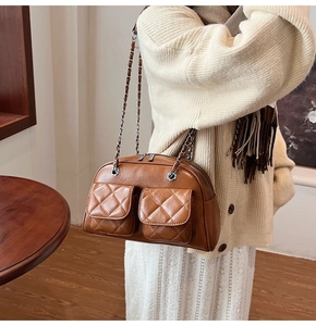 Detail of caramel brown quilted pillow bag with chain strap and dual pockets