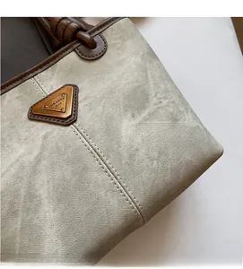 Detail of fabric texture and vintage triangular logo on a green tote bag