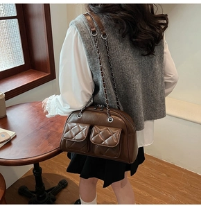 Close-up of retro brown quilted leather shoulder bag with chain strap in coffee shop