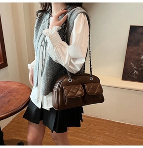 Close-up of retro brown quilted crossbody bag featuring dual front pockets and chain strap