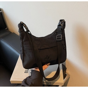 Dettaglio della borsa a mezzaluna in nylon nero con tracolla regolabile e fibbia