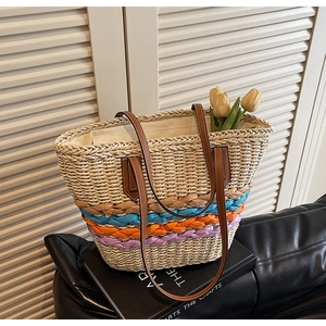 Close-up of handmade straw tote bag with colorful woven stripes and leather handles