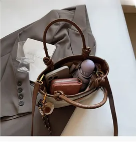 Top view of spacious interior of brown bucket bag with phone, wallet and umbrella