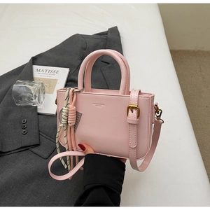 Close-up of pink crossbody bag showing leather texture and gold hardware details