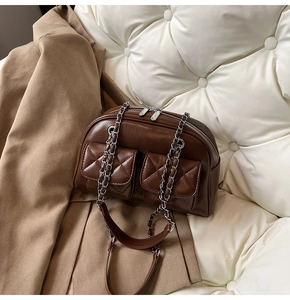 Detail of vintage brown quilted pillow bag with retro leather texture and chain strap
