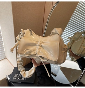 Macro view of the pleated handle and premium cream leather texture on the bag