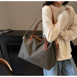 Deep olive green nylon tote bag featuring durable leather straps and spacious design