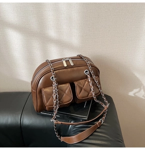 Close-up of vintage brown quilted leather shoulder bag with silver chain and dual pockets