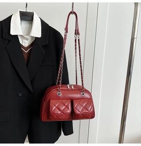 Close-up of vintage quilted wine red handbag with silver chain and dual front pockets