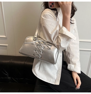 Silberne Boston-Tasche mit Schnürung im Korsett-Stil, von einem Model getragen