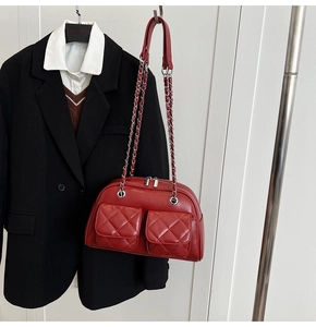 Detail of red quilted PU leather bag with silver chain strap and front double pockets