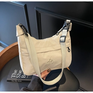 Dettaglio borsa a tracolla beige in nylon con fibbia regolabile e ricamo