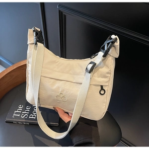 Dettaglio borsa a tracolla in nylon beige con fibbia in plastica e cerniera laterale