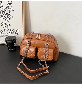 Detail shot of vintage brown quilted shoulder bag with silver chains and dual pockets