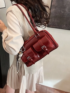 Deep red faux leather shoulder bag with front pockets and silver charm detail