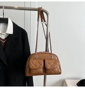 Detail of vintage brown quilted shoulder bag featuring dual pockets and silver chain strap