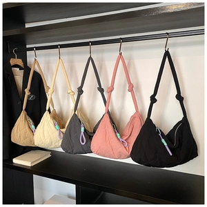 Detail of quilted crescent bags featuring knotted shoulder straps in multiple colors