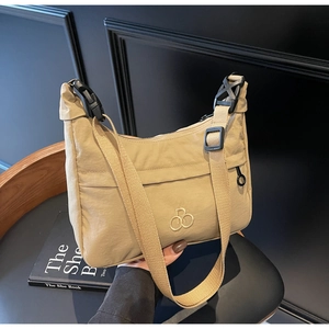 Dettaglio della borsa a mezzaluna in nylon kaki con tessuto impermeabile e logo dorato