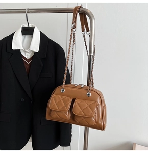 Detail of vintage brown quilted shoulder bag with dual front pockets and silver chain straps