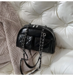 Close-up of black quilted pockets and silver hardware on a vintage pillow bag