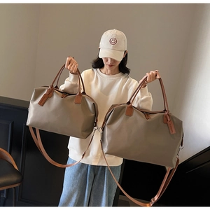 Size comparison of medium and large nylon travel bags with brown leather handles