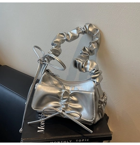 Close-up of metallic silver ruffled shoulder bag with chic front bow detail