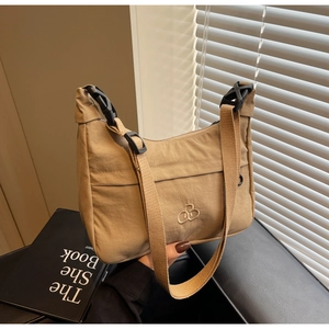 Dettaglio della borsa a mezzaluna in nylon kaki con tracolla larga e logo RO ricamato