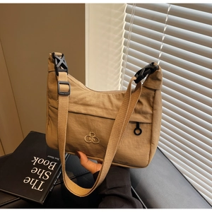 Dettaglio della borsa dumpling in nylon kaki con tracolla regolabile e logo RB ricamato