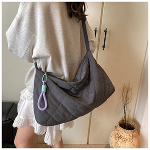 Detailed back view of large grey quilted tote bag with a woven decorative charm