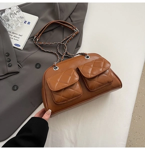 Brown quilted shoulder bag featuring retro chain strap on a stylish blazer background
